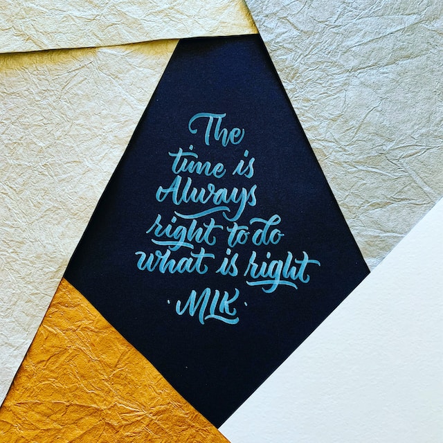 Text in painted text in script reading "The time is always right to do what is right MLK"