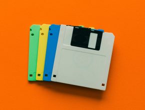 A photo of four floppy disks laying on an orange background